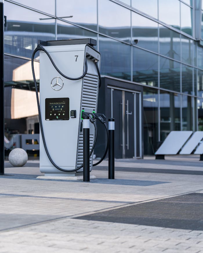 Modern electric vehicle charging station outside a glass building in the city.